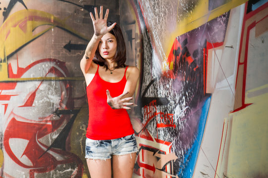 Beautiful Chinese Woman By Graffiti Walls With Hands Raised