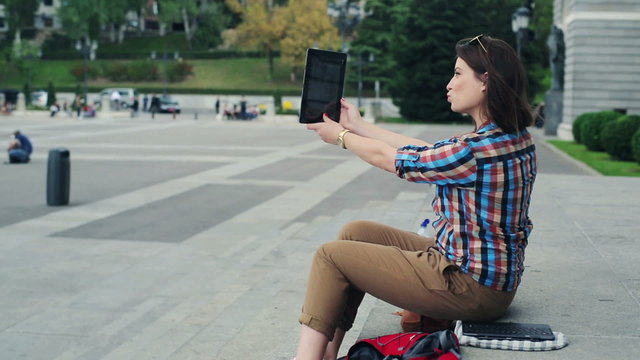 Pretty hipster woman talking selfie photo with tablet computer o