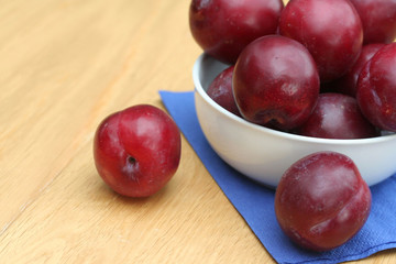 prugne rosse su tavolo di legno_ frutta
