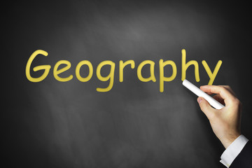 hand writing geography on black chalkboard