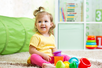 little girl playing on floor at home or kindergarten