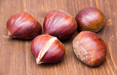 Chestnuts on wooden table seen from the front