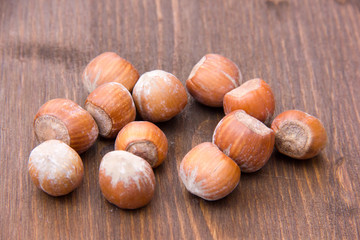 Hazelnuts on wooden table seen from the front