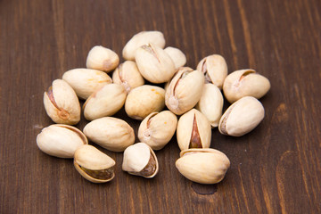 Pistachio nuts on wooden table seen from the front