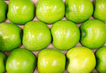 Row of green apples in supermarket.