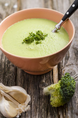 Brokkolicremesuppe in antiker Porzellanschale auf Holztisch