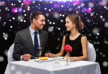 smiling couple eating dessert at restaurant