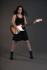 Fototapeta premium Teenage rock girl with electric guitar. Wearing black dress.