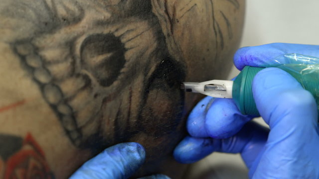 Tattoo artist tattooing a skull