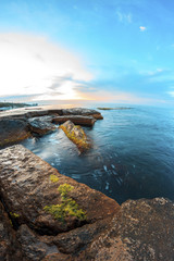 Sunrise on beach with rocks and sea