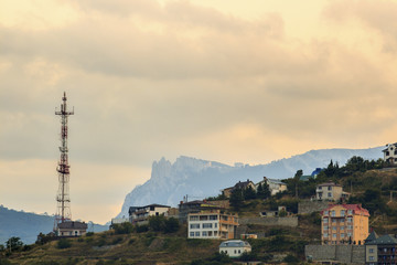 Radio tower and a building in the mountains at sunset