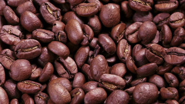 close up footage of rotating roasted coffee beans some zoom, som