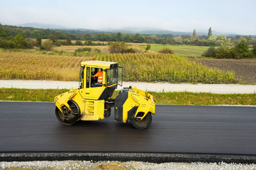 Gelbe Walze auf frischem Asphalt