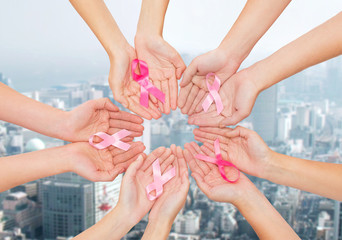close up of hands with cancer awareness symbol