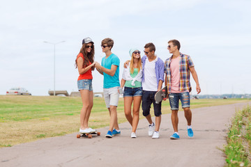 group of smiling teenagers with skateboards