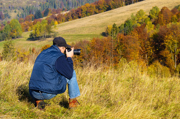 Man photographer in the mountains forest.