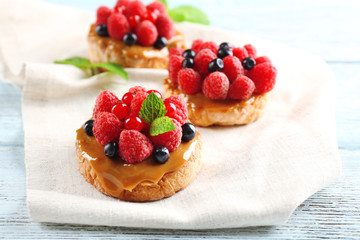 Sweet cakes with berries on table close-up