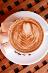 Cup of coffee with cute drawing in cafe