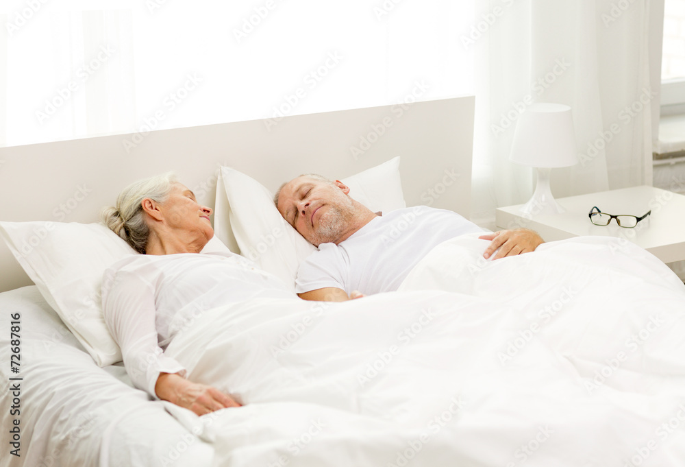 Poster happy senior coupler lying in bad at home