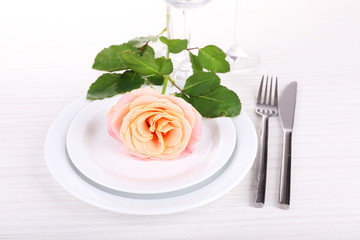 Table setting with pink rose on plate