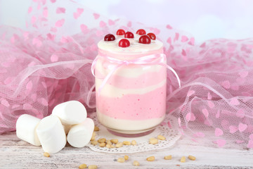 Raspberry milk dessert in glass jar,