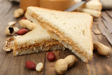 Bread slices with creamy peanut butter on wooden table