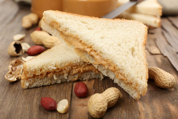 Bread slices with creamy peanut butter on wooden table