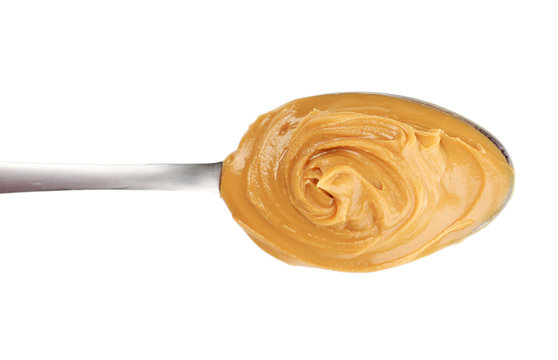 Creamy peanut butter in spoon, isolated on white