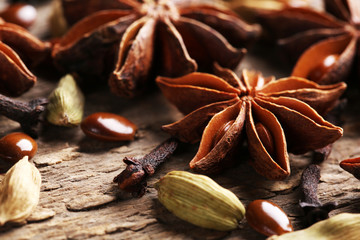 Stars anise with cardamom and carnation on wooden background