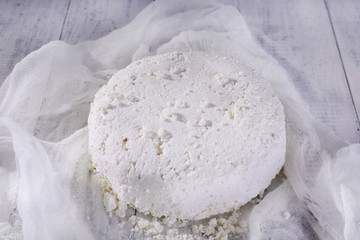 Cottage cheese on gauze on wooden background