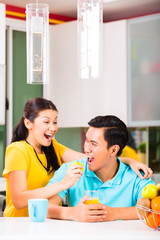 Asian woman feeding boyfriend with apple