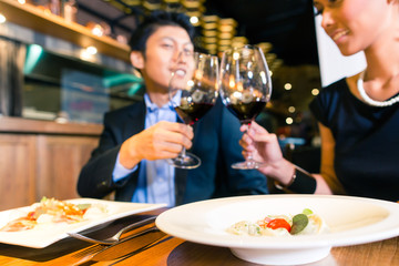 Asian couple toasting with red wine