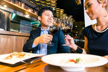 Asian couple toasting with red wine