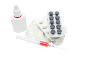 Pills in a blister pack, syringe with red liquid and nasal spray