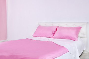 Fototapeta na wymiar Bed in pink bed linen in room