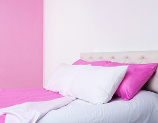 Bed in pink bed linen in room