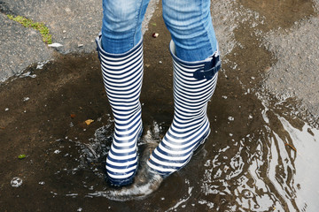 Girl in rubber boots outdoors in autumn
