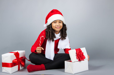 girl with a New Year gift. Joyful girl in a cap of Santa Claus