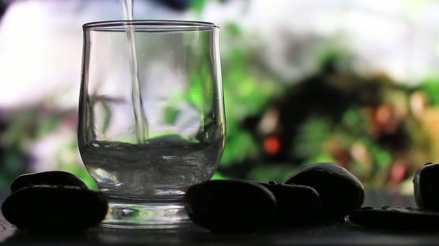 Glass of water on a background of a waterfall