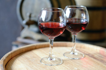 Glasses of wine in cellar with old barrels