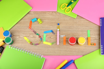 Inscription school lined of school supplies on wooden