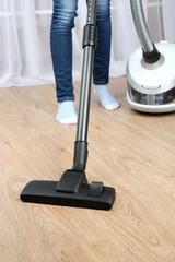 Woman with vacuum cleaner in room