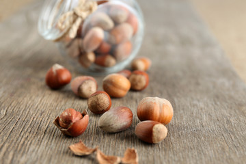 Hazelnuts in glass jar on wooden background