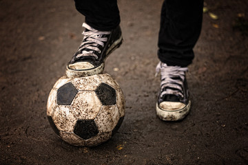 Soccer ball on ground in rainy day, outdoors
