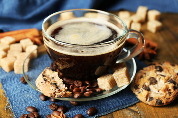 Cup of coffee and chocolate chip cookies on wooden background