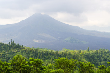 Sunrise in Amed, Bali, Indonesia. The active volcano Gunung Agung looms over the black sand beach of Jemeluk in the area known as Amed in the eastern shore of the tropical island of Bali.