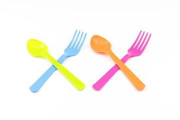 Colorful fork and spoon crossing on white background