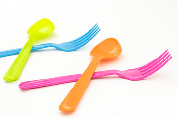Colorful fork and spoon crossing on white background