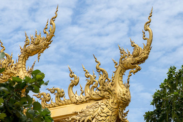 Fototapeta na wymiar Golden naga with blue sky on top of temple