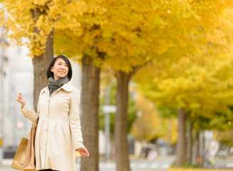 Fototapeta premium イチョウ並木を歩く女性